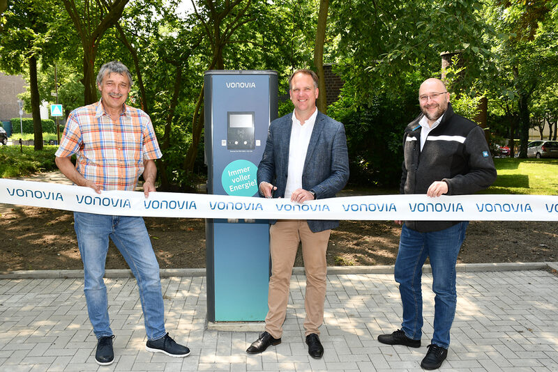 Hermülheims Ortsvorsteher Hans-Josef Lang, Bürgermeister Dirk Breuer und Vonovia-Regionalleiter Sascha Steiner (v.l.n.r.) nahmen mit Durchschneiden eines Flatterbandes eine neue Ladesäule für E-Fahrzeuge auf einer Parkfläche am Deutschen Ring in Betrieb.