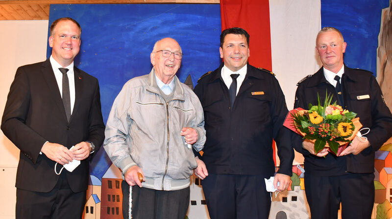 Alle Geehrten versammelten sich während der Jahresdienstbesprechung im Beisein von Bürgermeister Dirk Breuer und Stadtbrandmeister Michael Mund fürs Gruppenfoto. Auf der Bühne begrüßten Bürgermeister Dirk Breuer (l.), Stadtbrandmeister Michael Mund (2.v.r.) und dessen Stellvertreter Klaus Schmitz (r.) Pfarrer Rudolf Kusch (2.v.l.), der seit 2009 Ehrenmitglied der Hürther Wehr ist.