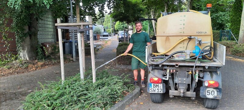 SWH-Mitarbeiter beim Gießen von Jungbäumen.