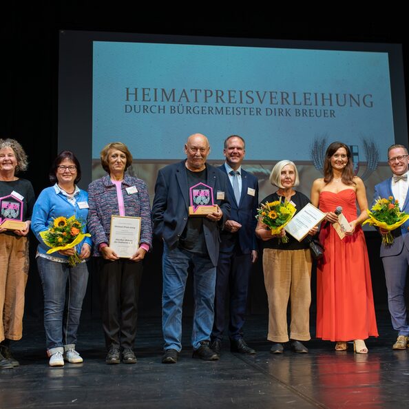 Bürgermeister Dirk Breuer gratulierte herzlich den Preisträgerinnen und Preisträgern des diesjährigen Heimatpreises: Anita und Karl Maria Fölling, Vertreterinnen und Vertretern der „Hürther Brücke der Kulturen“ sowie Andreas Nußbaum. Moderatorin Fabricia Karutz führte durch die Veranstaltung.