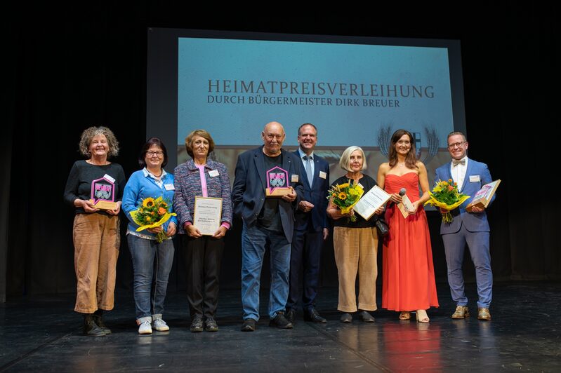 Bürgermeister Dirk Breuer gratulierte herzlich den Preisträgerinnen und Preisträgern des diesjährigen Heimatpreises: Anita und Karl Maria Fölling, Vertreterinnen und Vertretern der „Hürther Brücke der Kulturen“ sowie Andreas Nußbaum. Moderatorin Fabricia Karutz führte durch die Veranstaltung.