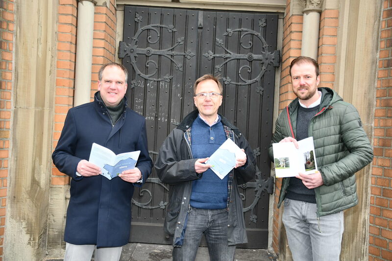 Präsentieren vorm Eingang der Kirche St. Severin die Neuerscheinung: (v.l.n.r.) Bürgermeister Dirk Breuer, Verfasser Bernd Gellert und Dennis Hübner, Verwaltungsleiter der katholischen Kirche in Hürth.