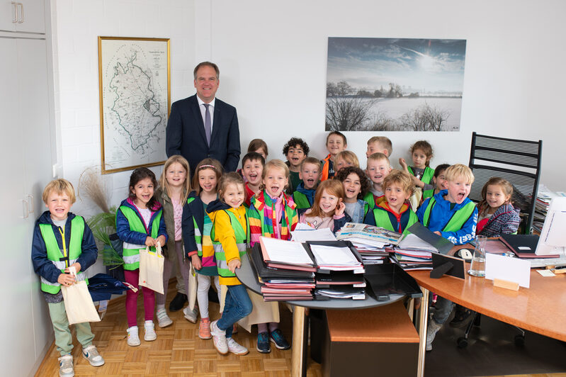 Die Kinder nehmen den Feuerwehrhelm des Bürgermeisters genau unter die Lupe.